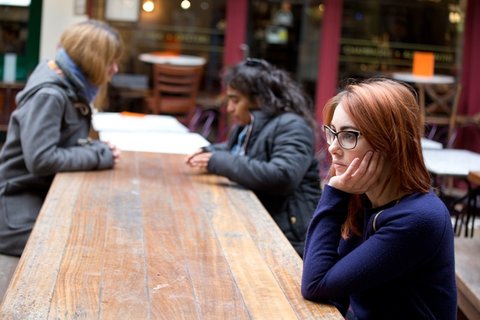Woman sat on her own looking despondent - Samaritans