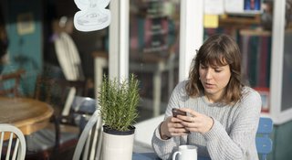 woman-reads-phone-outside