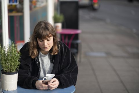 woman-text-outside-cafe
