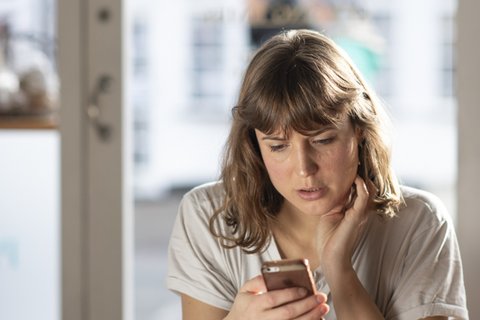 worried-woman-reading-phone
