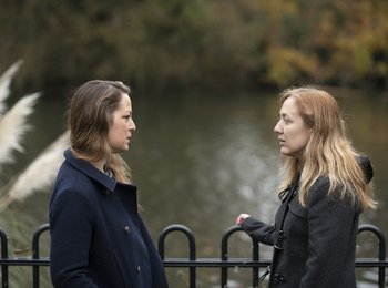 Two people stood talking in a park
