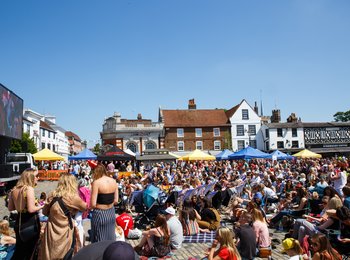 A picture of Hitchin market place with lots of people on a sunny day