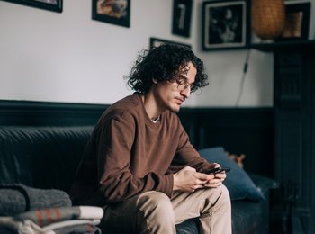 A man on the sofa looking at his phone