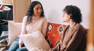 Man and woman sat on sofa talking at home (Home_294_AR)