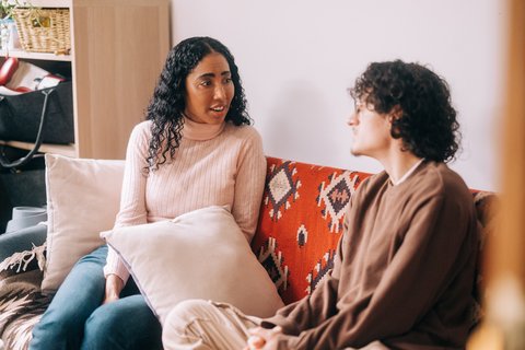 Man and woman sat on sofa talking at home (Home_294_AR)