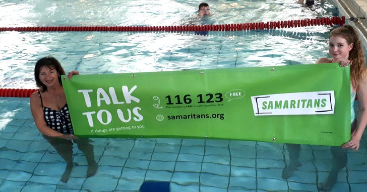 June 10 and Isabel holding Sams banner in swimming pool