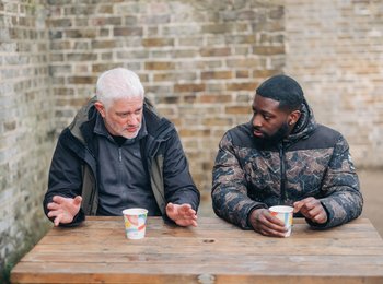 Two men on a bench outside