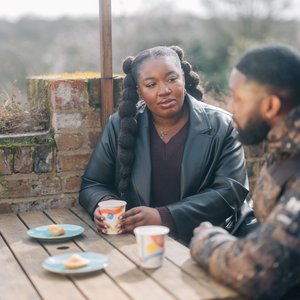 Two people sat outside talking on a bench (Outside_211_AR_)