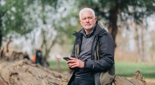 A man outside on his phone (Outside_444_AR)