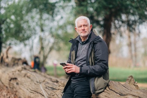 A man outside on his phone (Outside_444_AR)