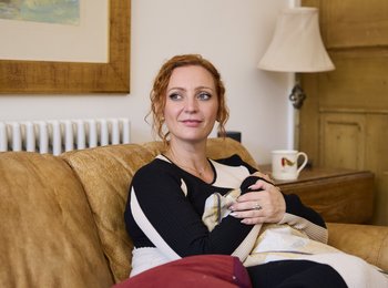 Anastasia is sitting on the sofa