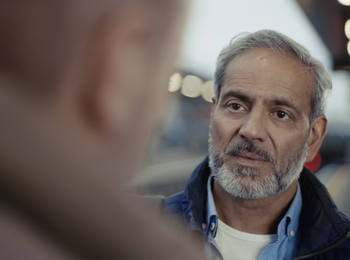 A man is talking to someone at a train station