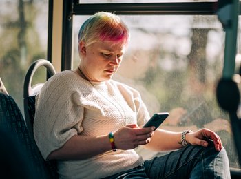 A woman on the bus looking at her phone