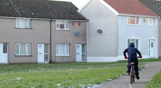 Child on bike outside a row of houses