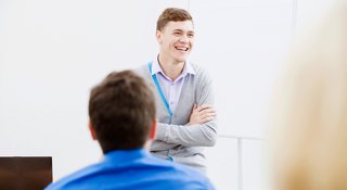 Young teacher in a classroom talking to students about mental health
