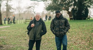two-men-walking-through-a-park